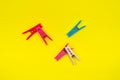 Multi-colored clothes pins on a yellow background Royalty Free Stock Photo