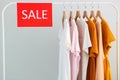 Clothes on the rail and a sale sign. Final sale, discounts Royalty Free Stock Photo