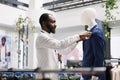 Clothes retail shop assistant dressing mannequing in formal suit Royalty Free Stock Photo