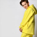 Studio portrait of a little boy in a warm yellow sports suit on a white background.