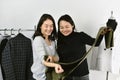 Clothes shop, Asian fashion designer working in her showroom studio, Dressmaker matching the best color for customer.