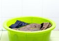 Clothes soak water in the green basin. Royalty Free Stock Photo