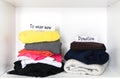 Clothes sorting in home wardrobe for wearing and donation on white shelf background