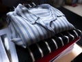 Clothes, teenage winter folded shirts, student in his bedroom with books underneath Royalty Free Stock Photo