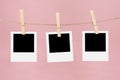 Clothesline with empty picture frames and clothespins on a pink background