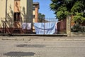 Clothesline in a yard of a condominium seen from behind a fence by the edge of a road in a village in the italian countryside in