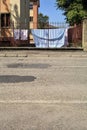 Clothesline in a yard of a condominium seen from behind a fence by the edge of a road in a village in the italian countryside in