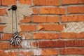 Clothespins for drying things hang on a rope on a nail against a brick wall