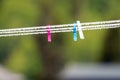 Clothespins outdoors on a string with fresh raindrops after rainy weather with green blurry background Royalty Free Stock Photo