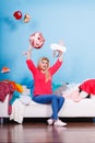 Woman sitting on messy couch throwing clothes Royalty Free Stock Photo