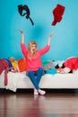 Woman sitting on messy couch throwing clothes Royalty Free Stock Photo