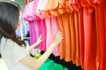 Clothing, Fashion, Style and People Concept. Young Asian Woman Buying Clothes in a Shopping Mall Store. Female Choosing or