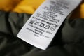 Clothing label with care symbols on color jacket, closeup