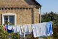 Clothing and linen dries after washing in the yard near the wall of the house Royalty Free Stock Photo