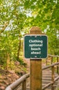 Clothing optional sign on post on trail to beach, British Columb Royalty Free Stock Photo