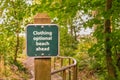 Clothing optional sign on post on trail to beach, British Columb Royalty Free Stock Photo