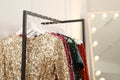 Clothing rack with colorful sequin party dresses on hangers in boutique, space for text Royalty Free Stock Photo