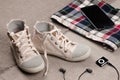 Clothing set. Womens sneakers and plaid shirt with lace insertion and black music player with headphones