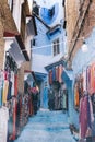 Clothing shops on a blue painted street in the medina of Chefchaouen, Morocco