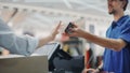 Clothing Store Checkout Cashier Counter: Handsome Courier Takes Package to Deliver for Online Order