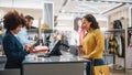 Clothing Store Checkout Cashier Counter: Woman and Male Retail Sales Managers Accept NFC Credit Card Royalty Free Stock Photo