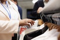 Clothing store worker restocking racks