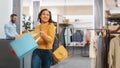 Clothing Store: Young Woman with Shopping Bags in Happy Mood Leaves Shop, Smiling, Spinning and Royalty Free Stock Photo