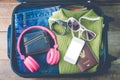 Clothing traveler`s Passport, wallet, glasses, watches, smart phone devices, on a wooden floor in the luggage ready to travel