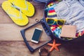 Clothing traveler`s Passport, wallet, glasses, watches, smart phone devices, on a wooden floor in the luggage ready to travel