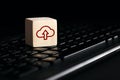 Cloud computing upload icon on wooden cube with computer keyboard. Remote download technology concept Royalty Free Stock Photo