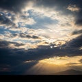Cloud-filled sky during sunset, with sun rays streaming through gaps, creat Royalty Free Stock Photo