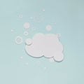 Cloud of foam with soap bubbles on pastel light-blue background.