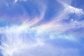 Cloud iridescence or irisation visible on the surface of white cirrus clouds; blue sky background Royalty Free Stock Photo