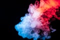 A cloud of isolated colored smoke exhaled from a vape: blue, red, orange, pink; on a dark background