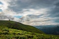 Cloud layers on mountain horizon with green grass