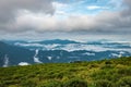 Cloud layers on mountain horizon with green grass Royalty Free Stock Photo
