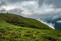 Cloud layers on mountain horizon with green grass