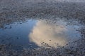 Cloud in puddle reflection gravel