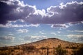 Stormy sky and promising rain clouds over a dry Kalahari desert hill