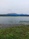 Cloud shrouded mountain seen from the edge of the reservoir