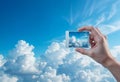 Cloud Storage Concept: Hand Holding Picture Against Cloudy Sky Background, Symbolizing Imagination and Creativity Royalty Free Stock Photo