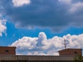 Cloud - towering cumulus - forming in the distance above the roof of the house Royalty Free Stock Photo