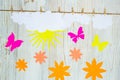 Cloud weather concept. Clouds, sun, flowers and paper butterflies are attached with clothespins Royalty Free Stock Photo