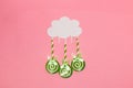 cloud from which handmade paper lollipops fall, creative art modern design, pink background