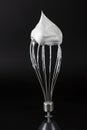 Cloud of whipped egg whites on whisk against black background Royalty Free Stock Photo