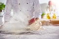 Cloud of flour kicked up by man rolling dough