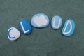 Cloud word conceptual composition with colored stones over green sand