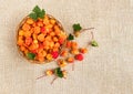 Cloudberry in a basket on a background of burlap. Healthy diet. Collecting forest ripe cloudberries from the forest