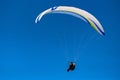 Cloudless photo of big white paraglider in blue sky