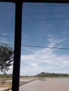 Cloudly day with half cloud taken in car and tree and lake